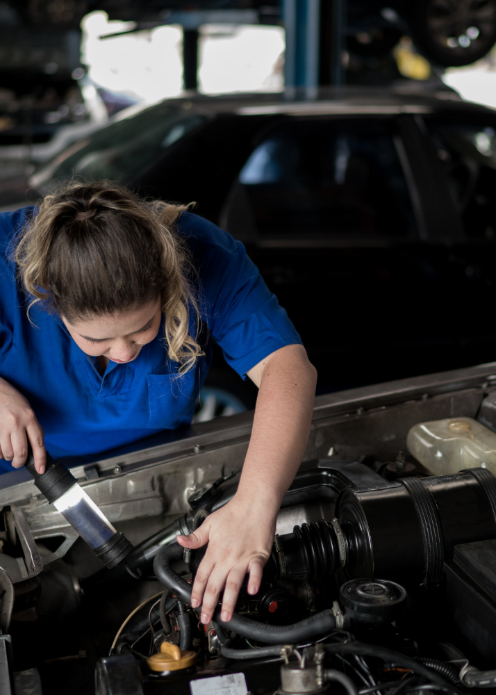 woman working on a car engine
