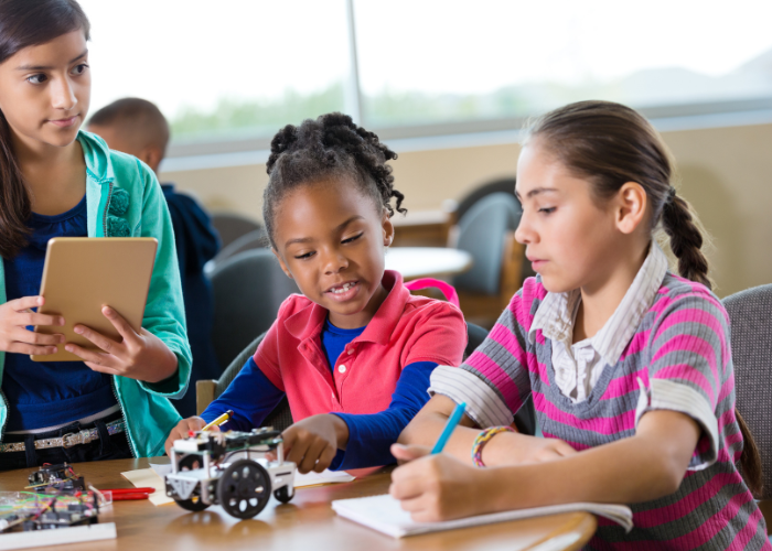 Three tween girls building a robot