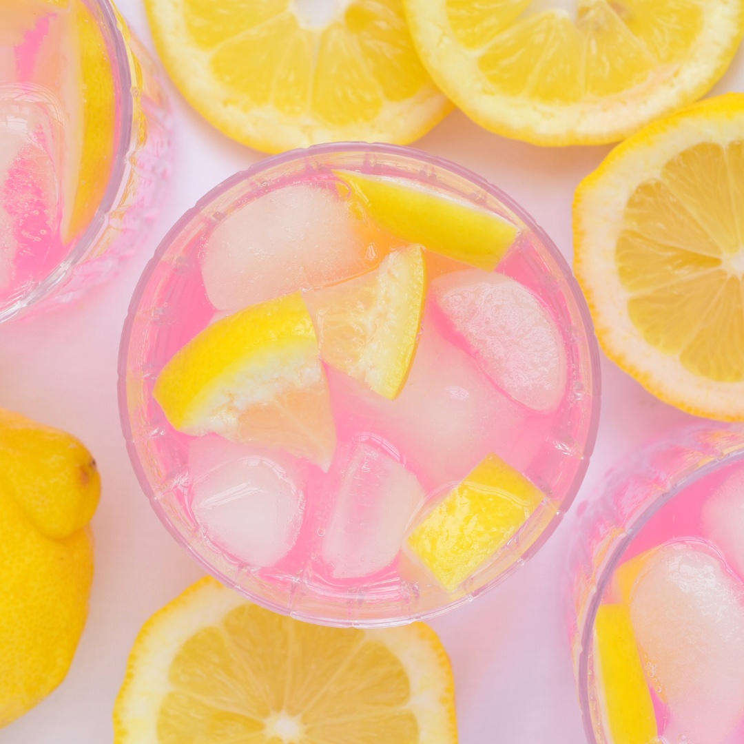 pink lemonade with ice and lemon wedges