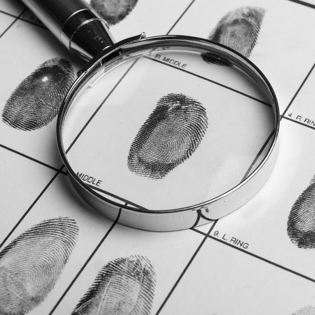 a sheet of paper with fingerprints on it and a magnifying glass